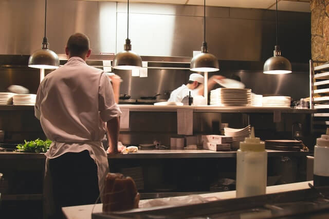 chef standing in restaurant kitchen - Omega Food Services